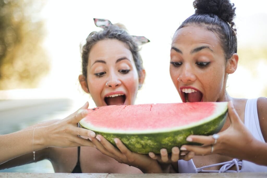 Mulheres praticando alimentação intuitiva comendo uma enorme melância.